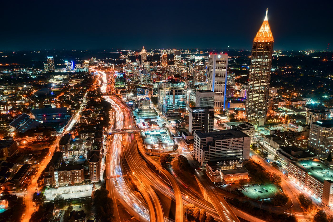 Downtown and Midtown Atlanta skyline at night with the interstate lit by traffic