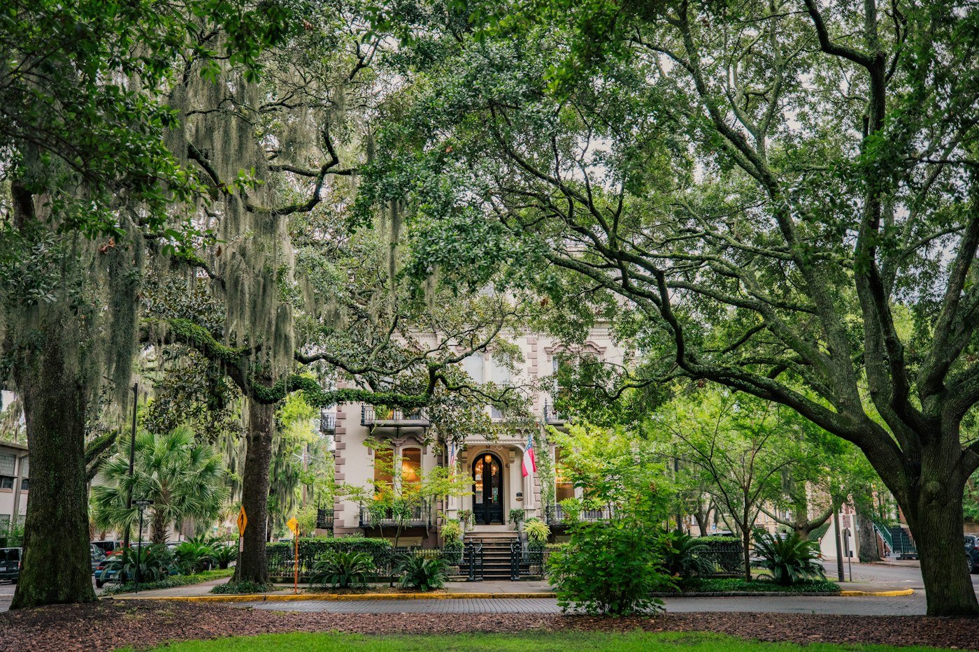 Spanish moss and live oaks frame a historic mansion on a Savannah square
